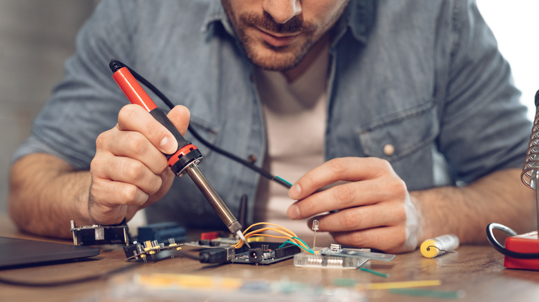 man using soldering iron