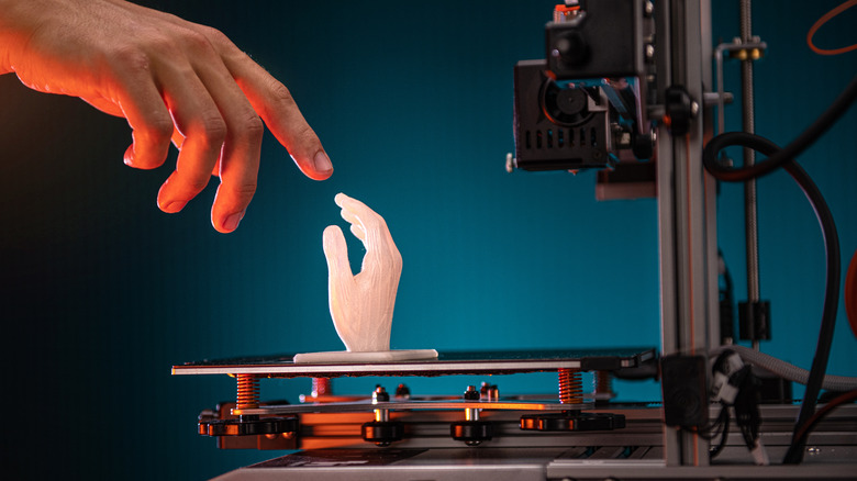 Human hand reaching out to 3D-printing hand