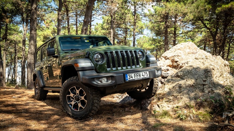 Green Jeep Wrangler going off-road