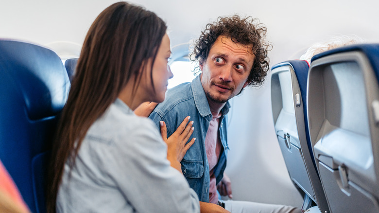 Woman comforting another passenger on an airplane