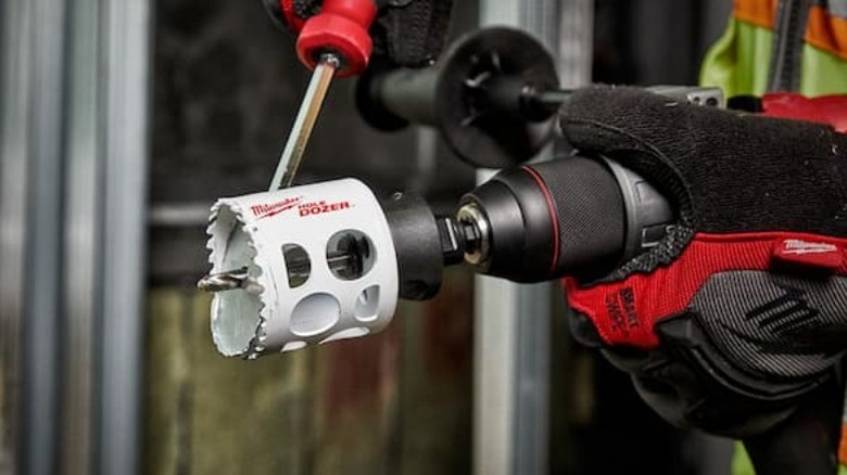 Person detaching Milwaukee Hole Dozer hole cutting saw