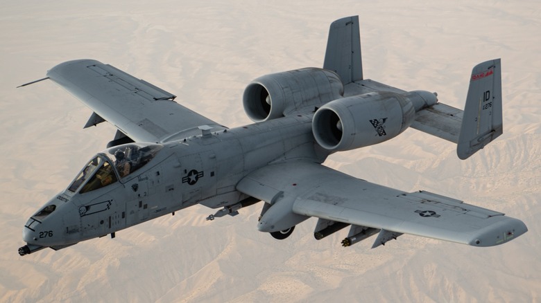 A-10 flying over desert/mountain terrain