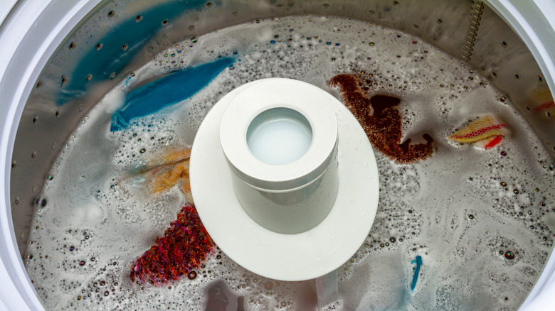 A washing machine drum full of water and clothes