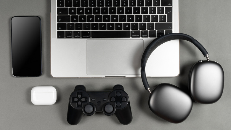 Laptop, controler, smartphone, earphones on display