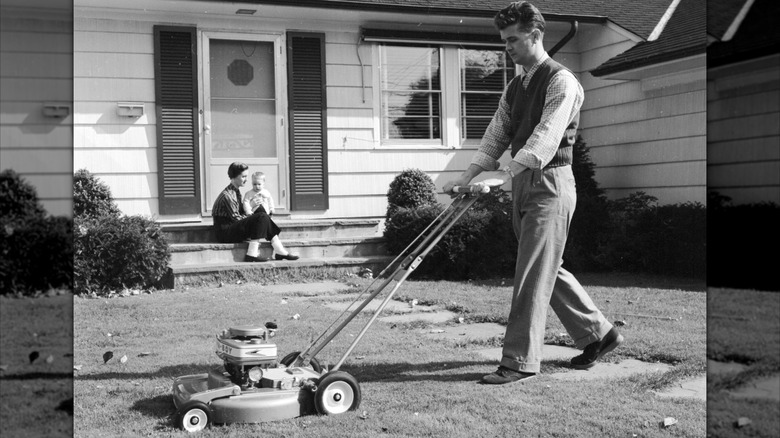A 1950s family with man mowing the lawn