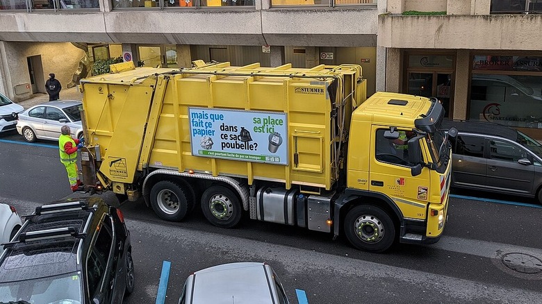 Yellow garbage truck in a Geneva street