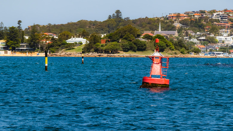 Red marker buoy swaying with the water currents