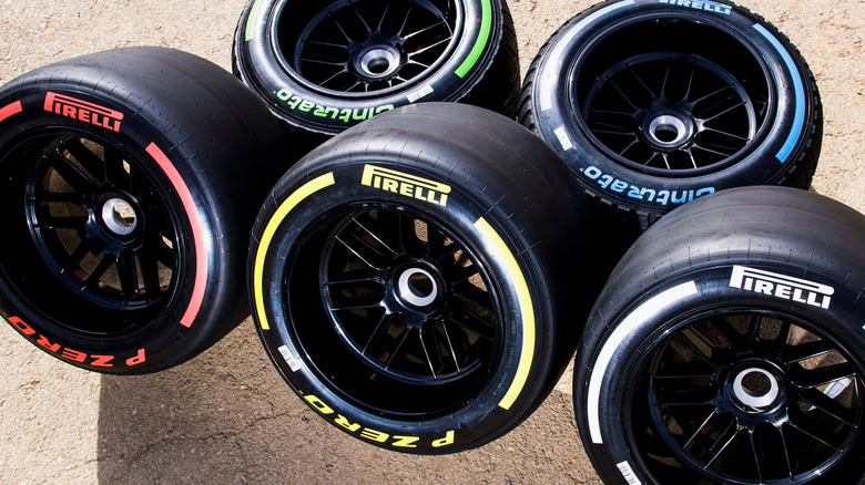 F1 slick and wet weather tires arranged on a concrete surface