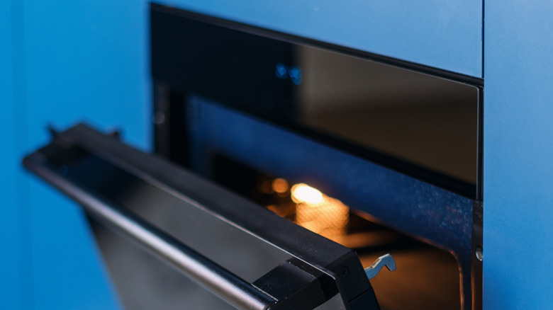 A close-up of an electric oven built into a sleek blue cabinetry in a kitchen