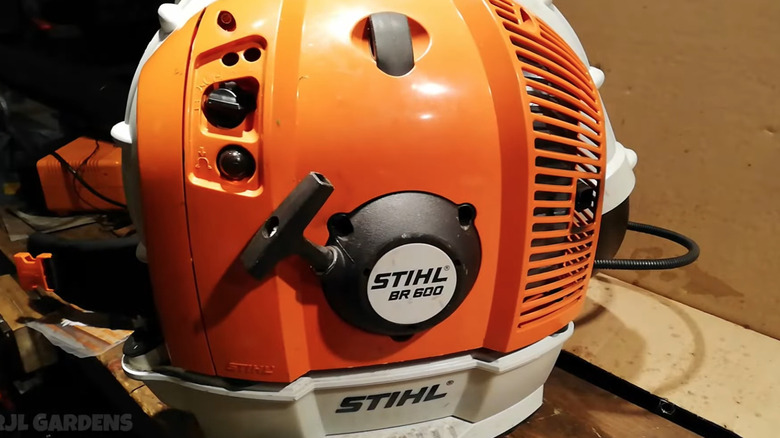 A close-up of a Stihl backpack blower with the choke valve indicator on the left