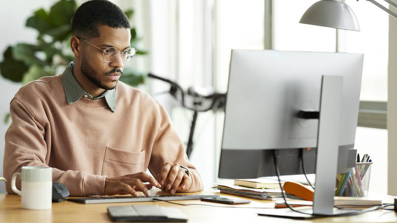 Man typing on a computer keyboard.
