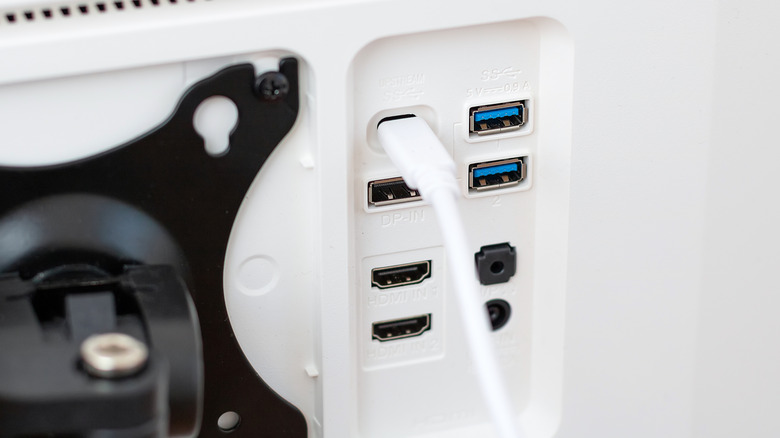 Ports on a white monitor with a USB-C cable plugged in.