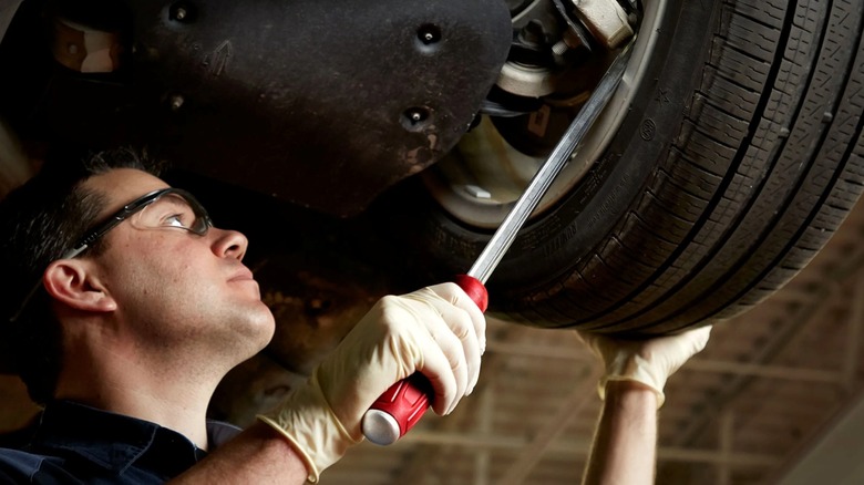 Person using Milwaukee pry bar on a car wheel