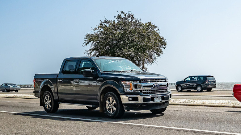Ford F-150 traveling down road, front-right three-quarter view