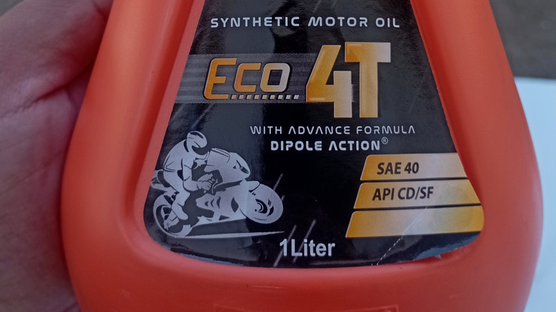 Close-up of container of 4T motorcycle oil showing the various standards