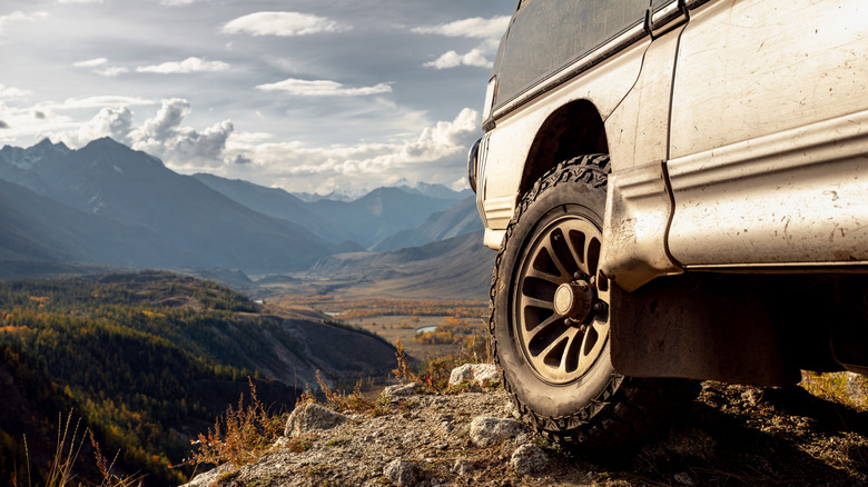 Close up photo of 4x4 wheel parked in mountainous terrain.