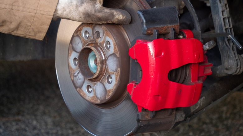 A red single piston disc brake caliper and rotor