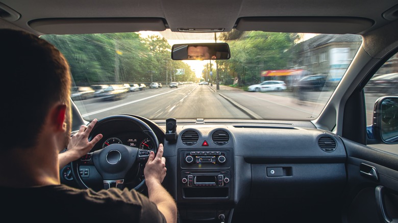 man driving on city street