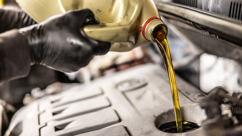 Mechanic pouring oil into an engine