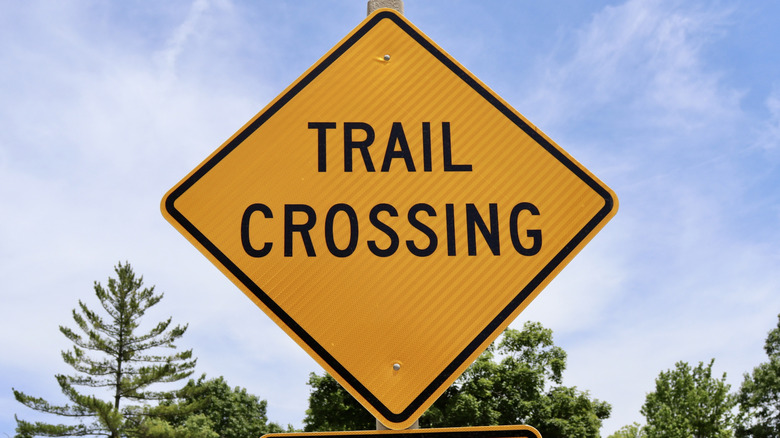 trail crossing yellow diamond road warning sign
