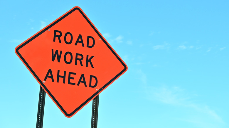 road work ahead orange warning road sign