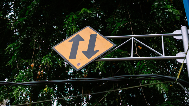 Low-angle photo of a two-way traffic sign above road