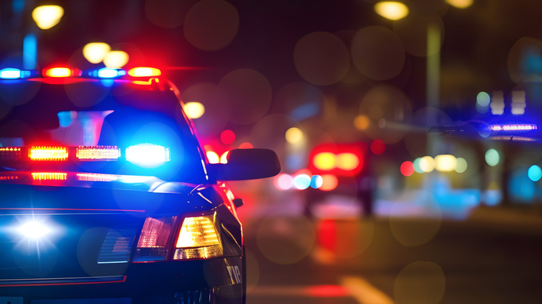 A cop car at night with lights and siren on
