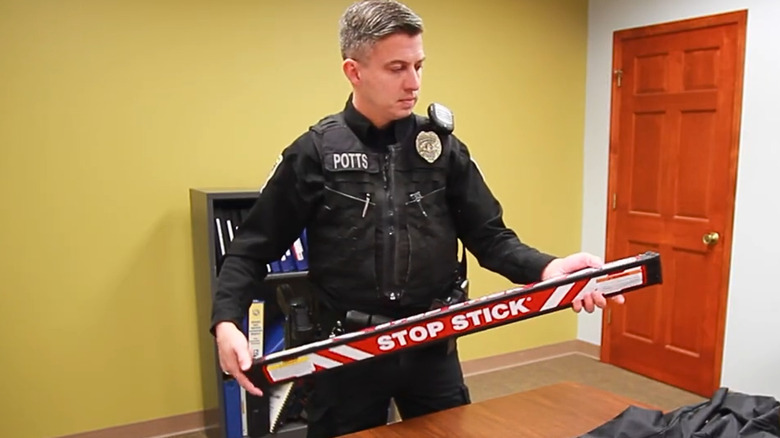 A police officer holding a Stop Stick