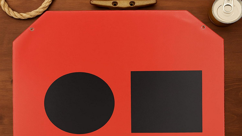 A Visual Distress Signal flag shown on a wooden tabletop