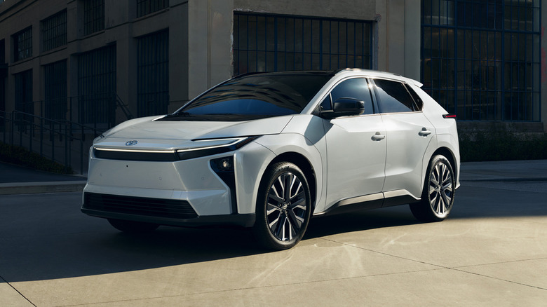 Front 3/4 view of the 2026 Toyota bZ, white exterior, old architecture in the background