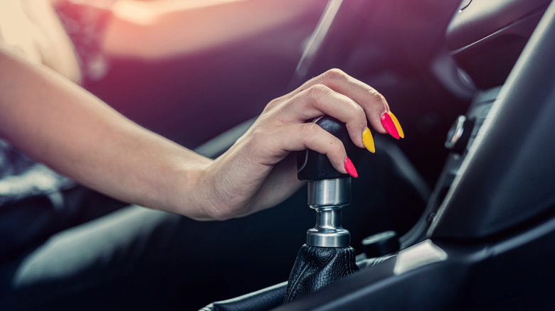 Someone's hand holding a gear stick.