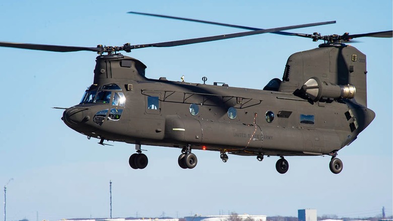 A U.S. Army CH-47 Chinook Helicopter hovering above a waterbody.