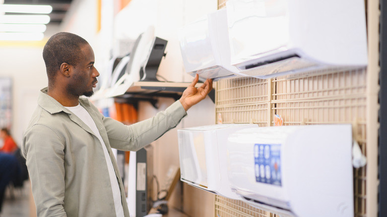 A man looks at air conditioning appliances inside a store