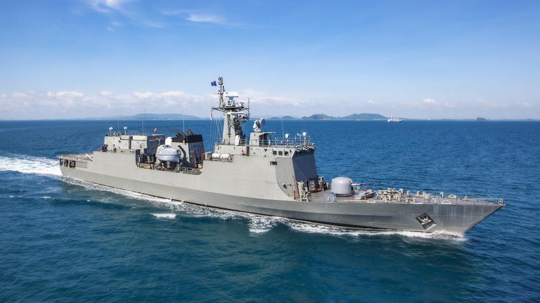 A Navy ship in a sea bay view from helicopter.