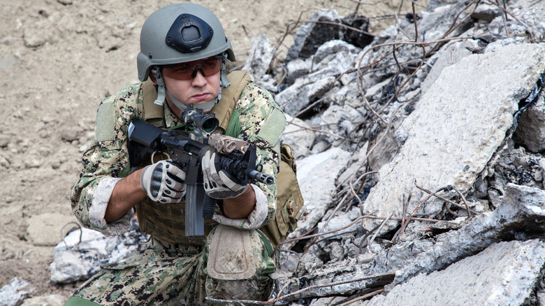 Navy SEAL crouched with gun ready to fire