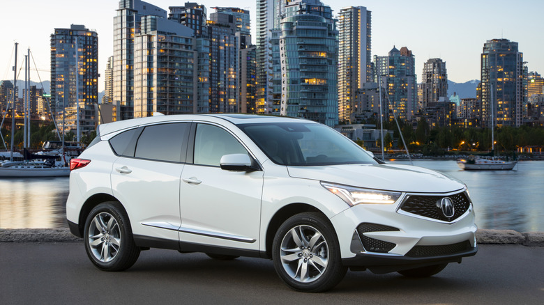 A white2019 Acura RDX parked in front of a city skyline