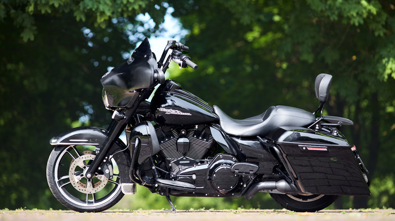 Side view of a black Harley-Davidson HD Street Glide on a sunny day with vegetation in the background
