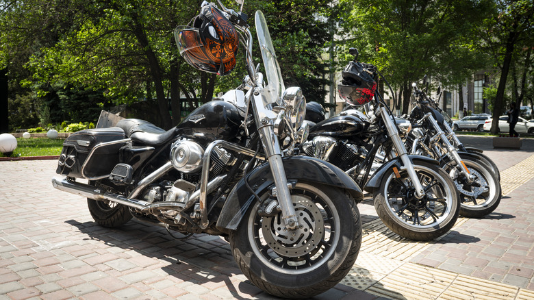 Harley-Davidson bikes parked with helmet on their handles