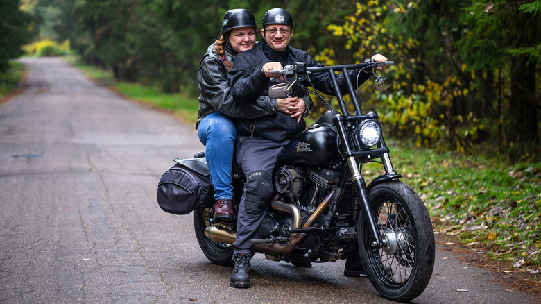 A couple riding black Harley-Davidson Dyna Street Bob