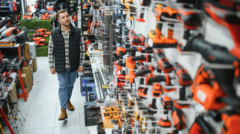 A man chooses a power tool in a hardware store