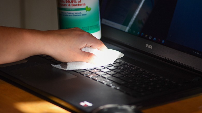 An employee at Hanscom Air Force Base disinfects a computer keyboard