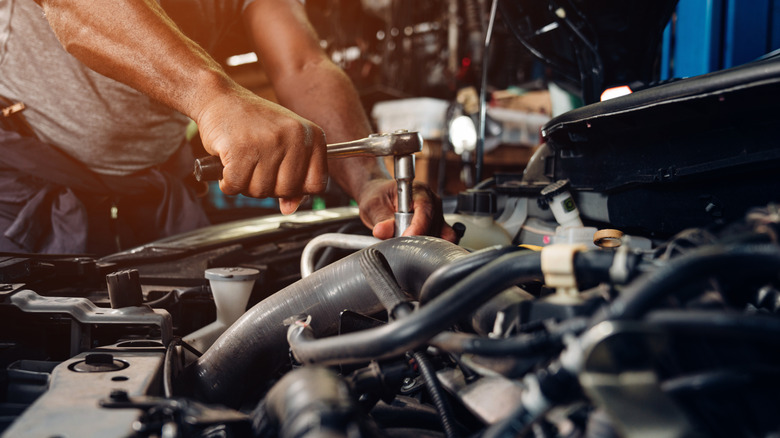 A mechanic fixes a car engine