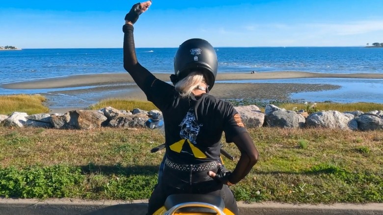 Biker tapping the top of their helmet