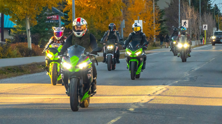 A group of motorcyclist riding together on a road.