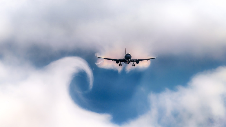 A plane creates wake turbulence trails behind itself