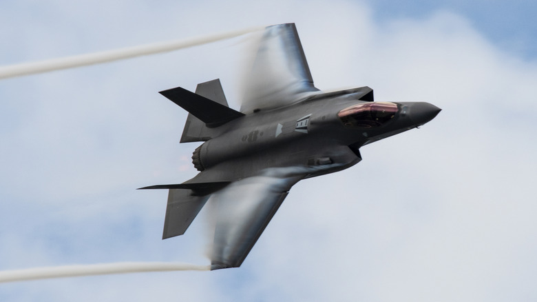 An F-35A Lightning II flying over cloudy skies