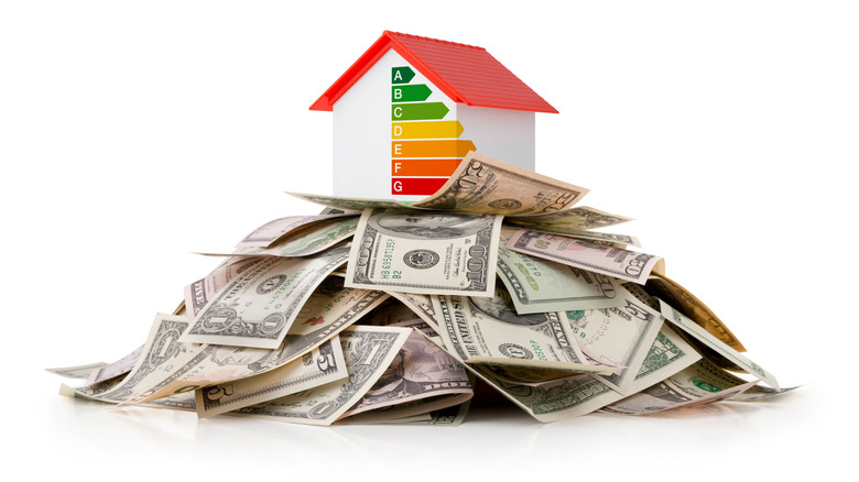 A miniature house on a stack of dollar bills.