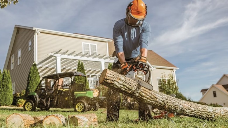 A Homeowner Using A STIHL Chainsaw To Cut Logs