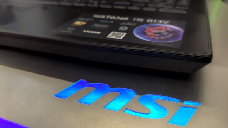 MSI's illuminated logo next to a laptop.