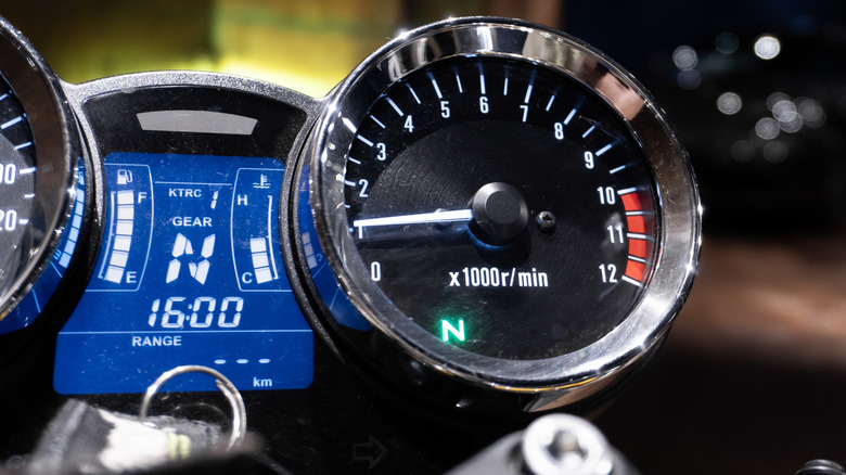 Close up of motorcycle dials and dash showing 'Neutral' engaged on both.